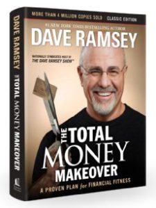 A picture of the The Total Money Makeover book cover, featuring a smiling Dave Ramsey holding a pair of scissors in the middle of cutting a credit card.
