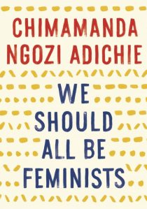 Cover of "We Should All Be Feminists," featuring the title in blue text on a background that is light yellow with darker yellow dashes and zig-zag patterns.