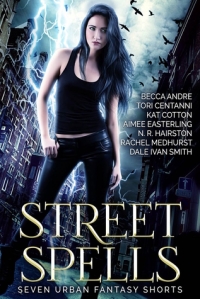 Cover of "Street Spells," featuring a young white woman with long black hair wearing black clothes and standing in a city street with lightning behind her