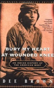 Cover of "Bury My Heart at Wounded Knee," featuring an old sepia-toned image of a Native American man seated with a bow and arrow across his knees.