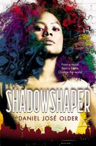 Cover of "Shadowshaper," featuring a girl with a dark afro bleeding into colorful swirls of paint that seem to be coming off the brick wall behind her.
